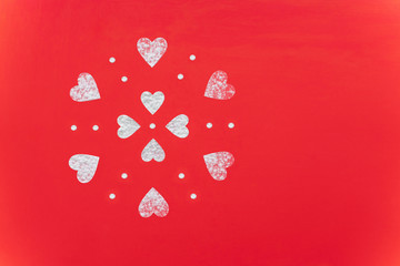 Heart shaped figures made of flour on a red background