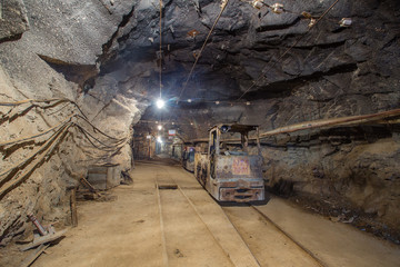 Fototapeta na wymiar Gold mine underground tunnel with electric locomotive