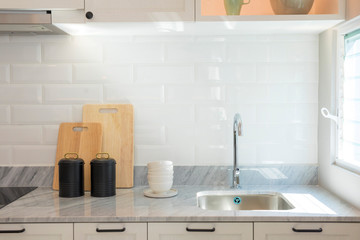 Close up of modern kitchen island with built in sink and white countertops