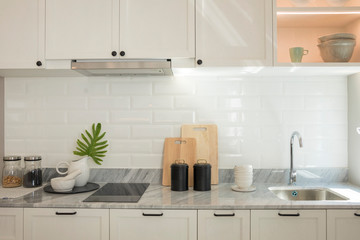 Close up of modern kitchen island with built in sink and white countertops