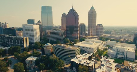 Aerial view of downtown Atlanta, Georgia and suburban neighborhoods in the state capital. Dron shot in a summer sunset featuring a beautiful skyline of Atlanta, Georgia USA.