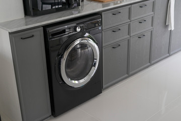 Interior of modern kitchen with washing machine. 