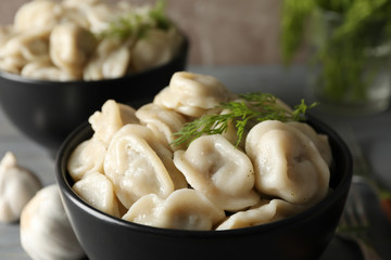 Bowls with dumplings on wooden table, close up