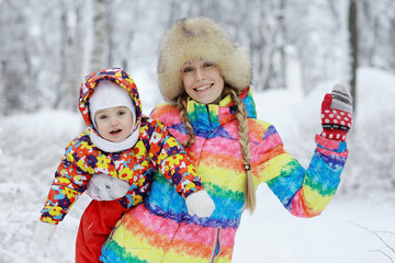 Little cheerful girl on a winter walk in the snow