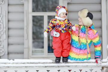 Fototapeta na wymiar small child and young mother in the winter outside in warm clothes fun
