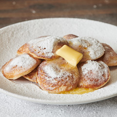 Dutch Mini Pancakes (Poffertjes). Fluffy mini pancakes that are served with a mess of powdered sugar and butter.