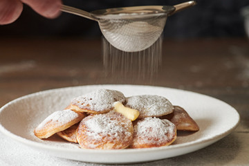Dutch Mini Pancakes (Poffertjes). Fluffy mini pancakes that are served with a mess of powdered sugar and butter.