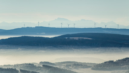 wind towers during sunset with mountains in the background