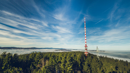 radio tower on a top of a hill in a forest