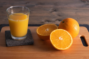 oranges and juice on a wooden board.