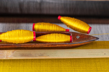 Weaving shuttle on weave silk cotton on the manual wood loom.