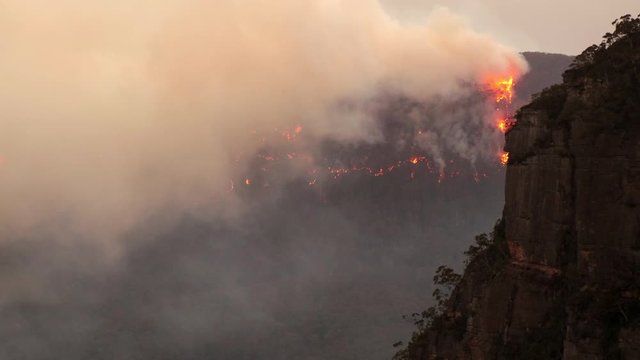 Australia bush fire with extreme smoke and visible flames burning up a ridge in the Blue Mountains
