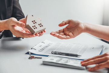 Woman customer sign agreement buying home ,salesman receive money after good deal after successful loan contract