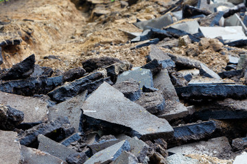 Pieces of broken asphalt. Road repair, close-up.