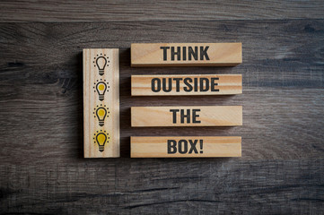Wooden pieces with lightbulbs and message Think outside the box