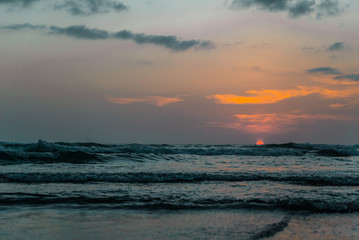 Sunset at a beach in Bali, Indonesia with waves
