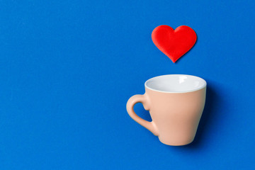 Holiday composition of red hearts falling out from a cup on colorful background. Top view of Saint Valentine's Day concept with copy space