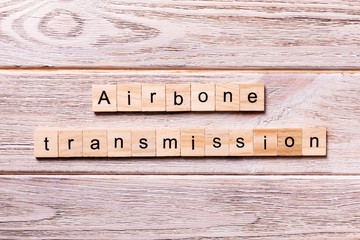 Airborne transmission word written on wood block. Airborne transmission text on wooden table for your desing, coronavirus concept top view