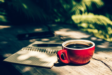 Coffee cup on the table near paper short note.
