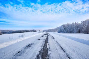 Winter landscape. Road through fields, forest and hills extending into the distance. Western Siberia. Salair Ridge. Russia.