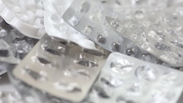 Seamless closeup loop of empty used pill blisters rotating