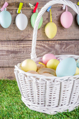 Colorful pastel Easter eggs on green and wooden garden terrace.  Funny spring decoration. Happy Easter greeting card background.