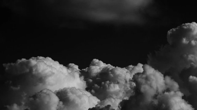 Black and white timelpase cloud. White clouds on black background time lapse video. Fluffy forming clouds.