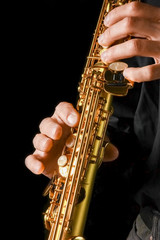 Fototapeta premium soprano saxophone in hands on a black background
