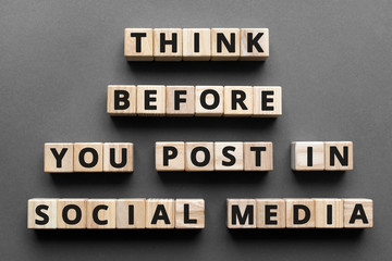 Think before you post in social media - words from wooden blocks with letters, social media activism concept, top view gray background