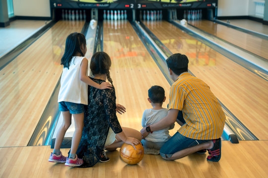 Young family having fun bowling