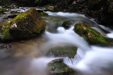Naklejka na ściany i meble Stones lie in water in mountain stream