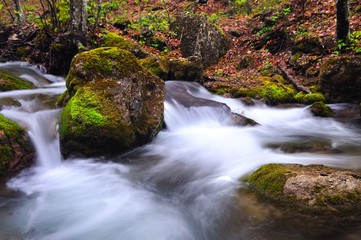 Obraz premium Stream with waterfall and mossy stones around