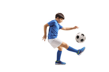 Boy football player juggling with a soccer ball