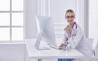 Portrait of a happy smiling young doctor in headset in office