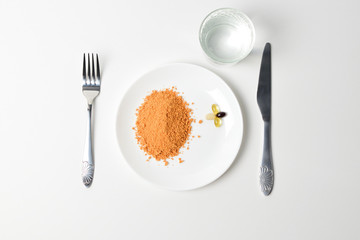 Tomato protein soup powder and multivitamins on a plate. Meal replacement. Dry soup. Multivitamins,...