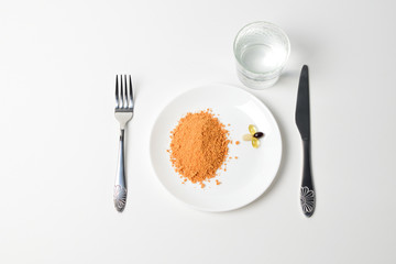 Tomato protein soup powder and multivitamins on a plate. Meal replacement. Dry soup. Multivitamins, astaxanthin, fish oil, omega pills.