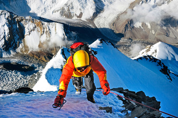 Climber ascending the summit of mountain peak. Climbing and mountaineering sport concept, Nepal Himalayas - obrazy, fototapety, plakaty