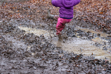 Young children playing in a muddy puddle