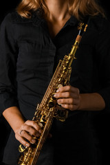 Obraz premium soprano saxophone in hands on a black background