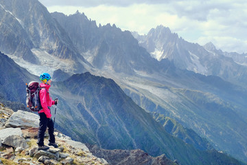 Fototapeta premium Woman Hiker with backpacks relaxing on top of a mountain and enjoying the view of valley
