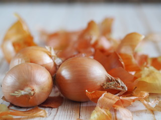 The use of onion skins in medicine and for coloring Easter eggs. Onion skin and onion on a wooden background. Onion is a storehouse of vitamin.