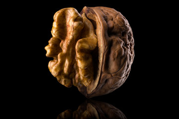 Macro photo of half opened walnut with kernel isolated on a black background