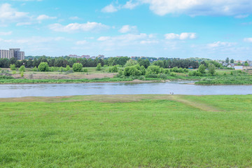 Fototapeta na wymiar Beautiful summer landscape of empty grass field near river. Landscape on banks of Neris river in Kaunas city, Lithuania. .