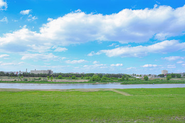 Obraz premium Beautiful summer landscape of empty grass field near river. Landscape on banks of Neris river in Kaunas city, Lithuania. .