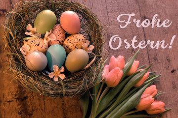 Osternest mit bunten Eiern und Text FROHE OSTERN