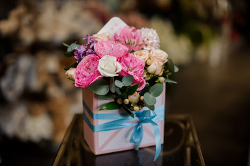 Tender box full of white, creamy color and pink roses decorated with green leaves