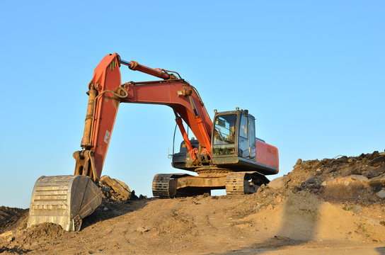 Excavator at a construction site during earthworks and laying of underground pipes. Professional excavation contractor serving, trenching, grading for residential, commercial, and municipal projects.