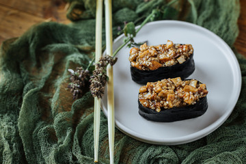 Sushi with eel is served on a white plate with chopsticks