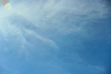 blue sky with a white touch clouds. bright blue sky with a slight haze of feather clouds
