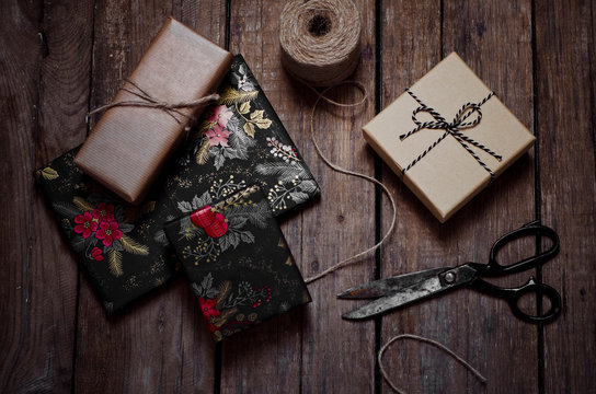Wrapped Christmas gifts, scissors and string on wooden table